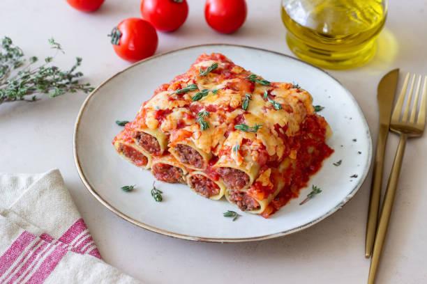 Cannelloni with meat, cheese, tomatoes and thyme. Italian cuisine